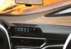 Który system infotainment najmniej rozprasza kierowcę? Test ergonomii i logiki menu Współczesne wnętrze auta z cyfrowym kokpitem podczas jazdy o zmierzchu