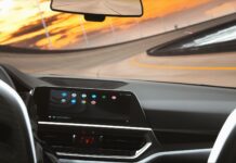 Który system infotainment najmniej rozprasza kierowcę? Test ergonomii i logiki menu Współczesne wnętrze auta z cyfrowym kokpitem podczas jazdy o zmierzchu