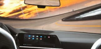 Który system infotainment najmniej rozprasza kierowcę? Test ergonomii i logiki menu Współczesne wnętrze auta z cyfrowym kokpitem podczas jazdy o zmierzchu