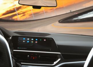 Który system infotainment najmniej rozprasza kierowcę? Test ergonomii i logiki menu Współczesne wnętrze auta z cyfrowym kokpitem podczas jazdy o zmierzchu