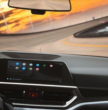 Który system infotainment najmniej rozprasza kierowcę? Test ergonomii i logiki menu Współczesne wnętrze auta z cyfrowym kokpitem podczas jazdy o zmierzchu